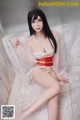 A woman in a red and white lingerie sitting on a marble bench.