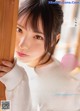 a japanese woman is leaning against a wooden wall