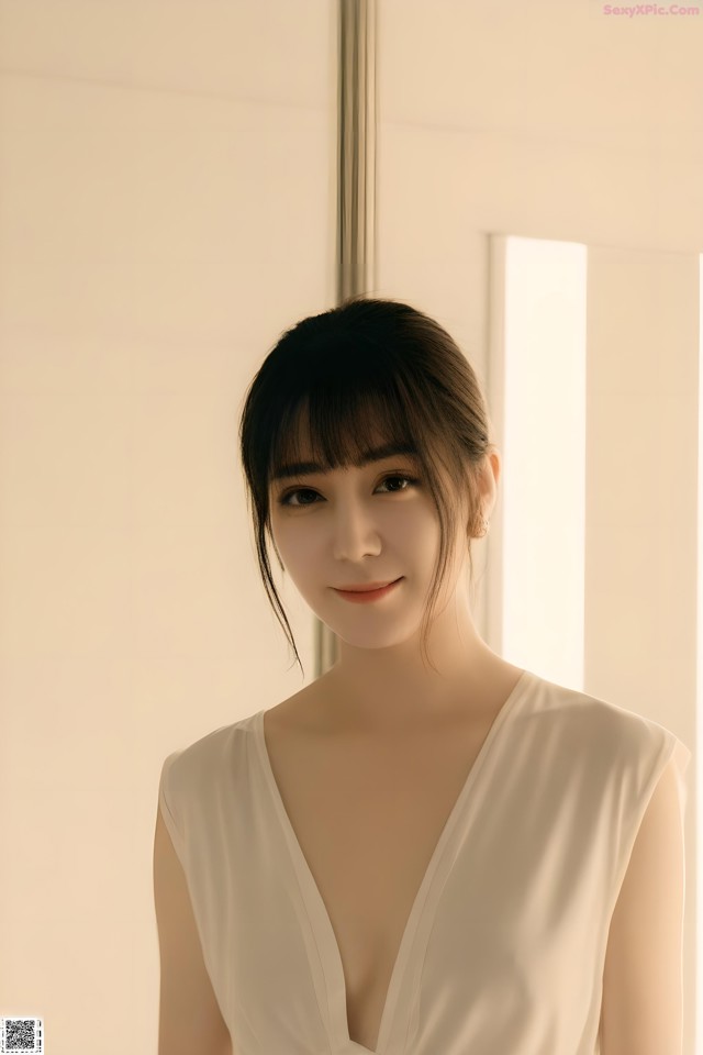 A woman in a white dress posing for a picture.