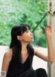 A woman sitting in front of a window looking out the window.