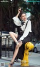 A woman sitting on top of a yellow fire hydrant.