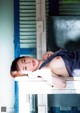 A woman laying on top of a white table.