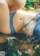 A woman laying on a wooden floor surrounded by flowers.