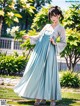 A woman in a blue dress standing in a park.