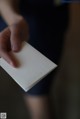 A person holding a white business card in their hand.