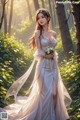 A woman in a wedding dress standing in the woods.