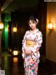 A woman in a kimono standing in a hallway.